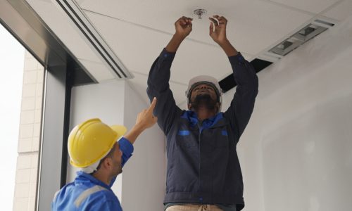 Engineers team installing fire sprinkler in office at building site, Technicians workers checking fire alarm systems and automatic sprinkler systems at new building construction site